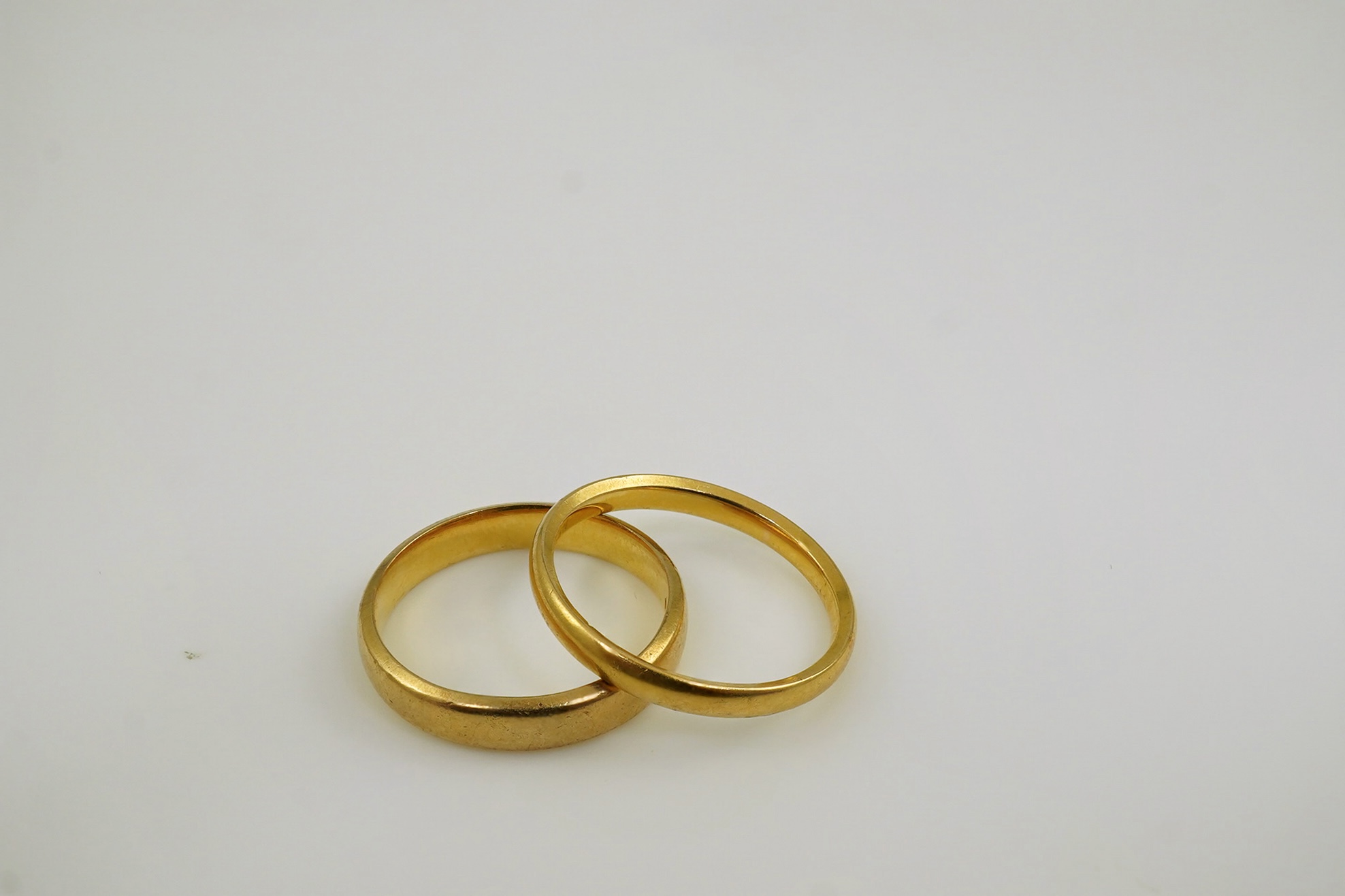 A late Victorian 22ct gold wedding band, London, 1885, size O and a later 22ct gold wedding band